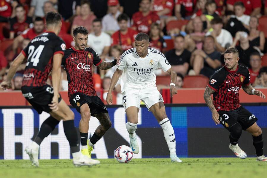 Útočník Realu Madrid Kylian Mbappé v obkolesení hráčov RCD Mallorca, úplne vľavo Martin Valjent (24) v zápase Mallorca vs Real Madrid v 1. kole La Ligy 2024/25