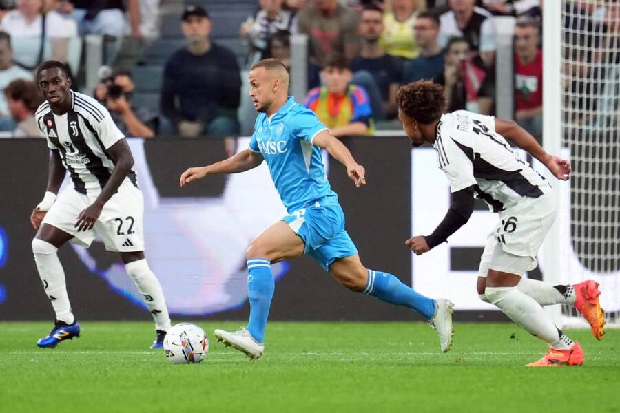 Slovenský stredopoliar Neapola Stanislav Lobotka (v strede) sledovaný dvoma protihráčmi v zápase 5. kola Juventus FC vs. SSC Neapol v Serie A 2024/2025