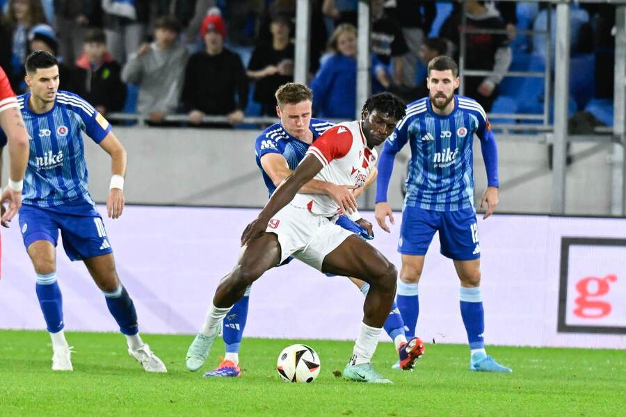 Trenčiansky útočník Chinonso Emeka sa snaží udržať loptu v súboji so Siemenom Voetom, zľava sleduje situáciu Marko Tolić a sprava Kenan Bajrić (všetci Slovan) v zápase Slovan vs. Trenčín v 10. kole Niké ligy 2024/2025